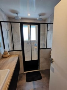 Photo d'une salle de bain avec une verrière noire créée sur mesure par VOLUMETAL